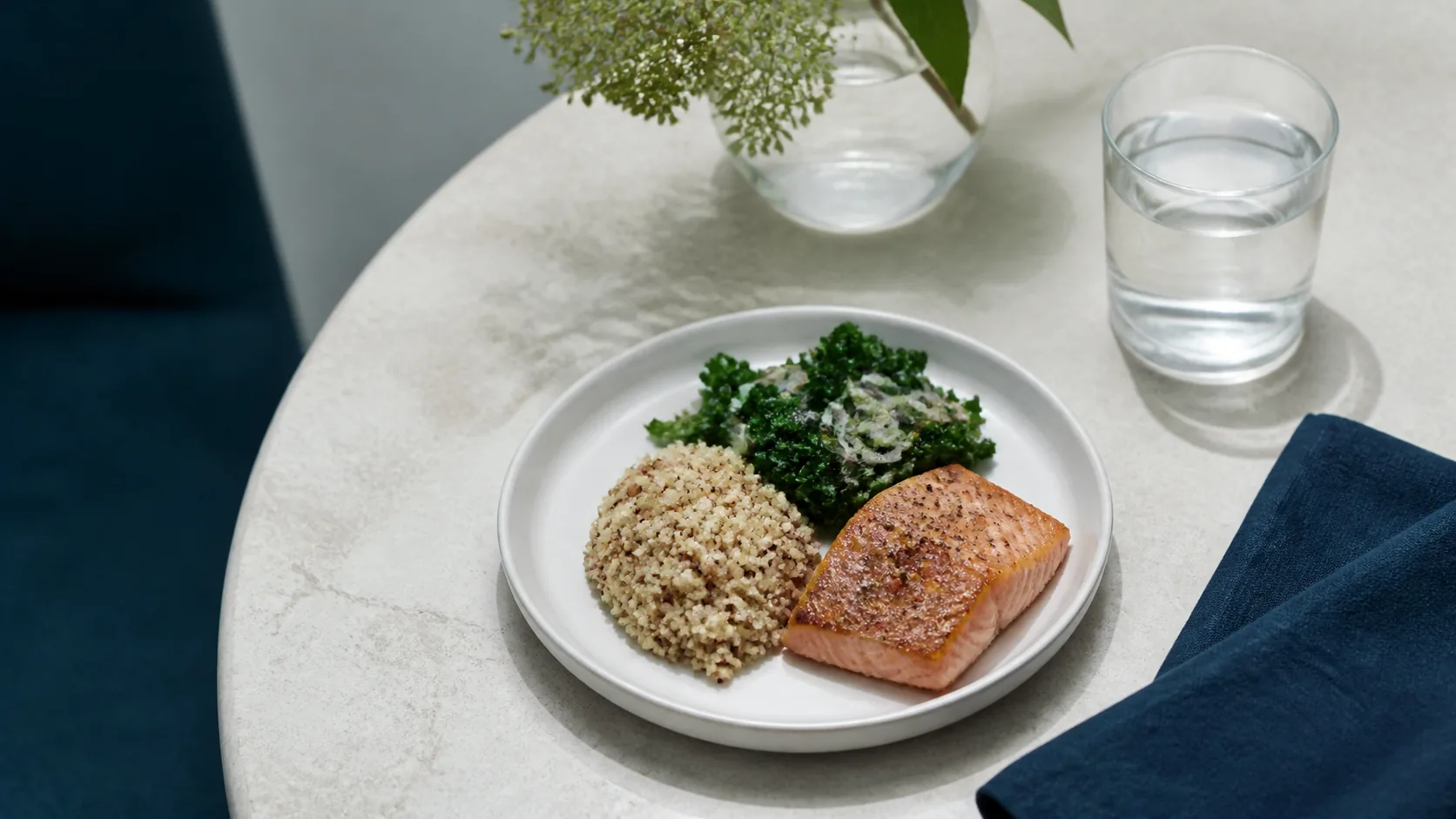 Photoreal editorial overhead still life of a small white ceramic plate holding a modest, carefully portioned meal of grains